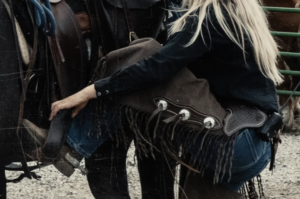 Cowgirl saddling a horse at Bull Hill Guest Ranch